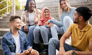 Group of multiracial young people talking on steps
