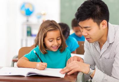 teacher helping student at her desk