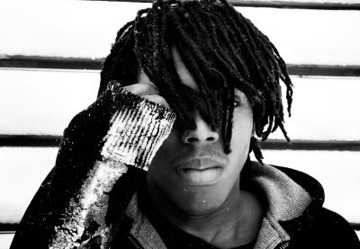 A boy, his face covered by his hair and hand, is pictured outside in snowy weather