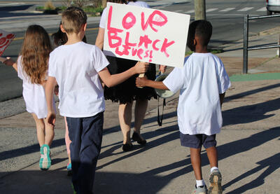 Students marching together holding a Black Lives Matter sign