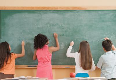 Kids writing on a chalk board.