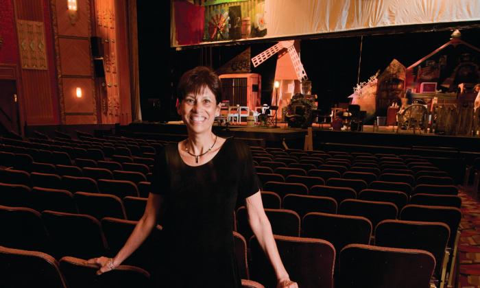 Teacher poses in front of the stage
