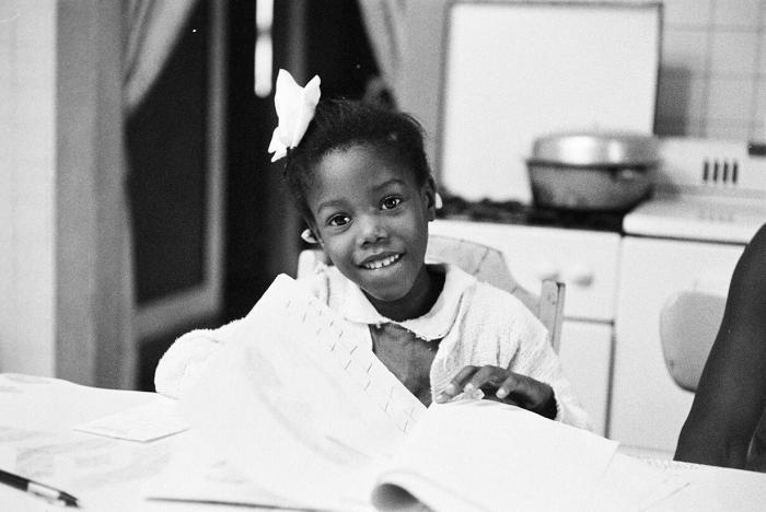 Ruby Bridges smiling as she does her homework